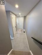 Hallway with baseboards and light tile patterned floors - 