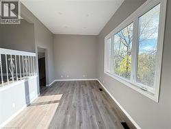 Unfurnished room featuring light wood-style flooring and baseboards - 
