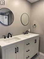 Bathroom with double vanity and light tile patterned flooring - 