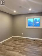 Unfurnished room featuring wood finished floors, recessed lighting, and a smoke detector - 