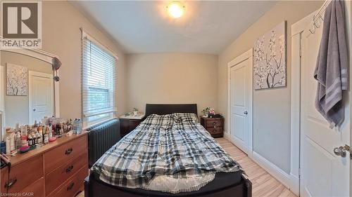 Bedroom with radiator heating unit and light wood-style floors - 25 Spadina Avenue, Hamilton, ON - Indoor Photo Showing Bedroom