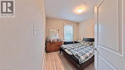 Bedroom with light wood finished floors and radiator heating unit - 
