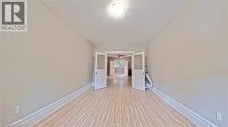 Hallway with baseboards and light wood-style floors - 