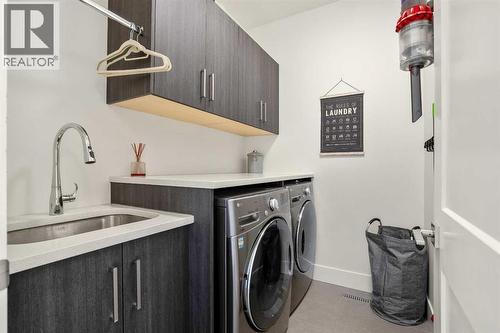 Upper Floor Laundry Room- Conveniently Located + Sink & Storage Cabinets - 303 30 Avenue Ne, Calgary, AB - Indoor Photo Showing Laundry Room