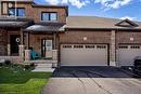 View of front of property with brick siding, a porch, a front yard, asphalt driveway, and a shingled roof - 24 Tamarack Way, Simcoe, ON  - Outdoor 
