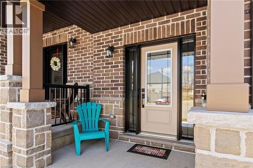 Entrance to property featuring covered porch and brick siding - 24 Tamarack Way, Simcoe, ON - Outdoor With Deck Patio Veranda With Exterior