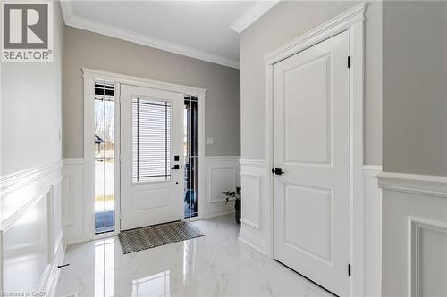 Foyer with crown molding, light marble finish flooring, a wainscoted wall, and a decorative wall - 24 Tamarack Way, Simcoe, ON - Indoor Photo Showing Other Room