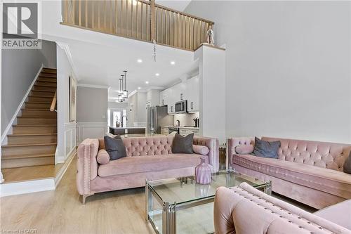 Living area featuring a wainscoted wall, light wood finished floors, crown molding, recessed lighting, and a high ceiling - 24 Tamarack Way, Simcoe, ON - Indoor Photo Showing Living Room