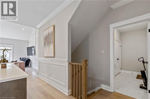 Corridor with crown molding, light wood-style floors, an upstairs landing, lofted ceiling, and a decorative wall - 24 Tamarack Way, Simcoe, ON - Indoor Photo Showing Other Room