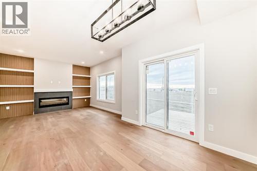 Patio doors leading to your back deck and yard - 508 Heritage Boulevard, Cochrane, AB - Indoor With Fireplace