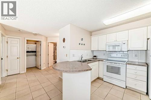 111, 6900 Hunterview Drive Nw, Calgary, AB - Indoor Photo Showing Kitchen With Double Sink