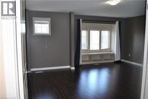 Unfurnished room featuring plenty of natural light, a textured ceiling, and dark wood-type flooring - 154 Harding Street, Kitchener, ON - Indoor Photo Showing Other Room