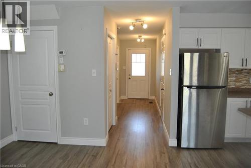 Kitchen with freestanding refrigerator, white cabinetry, decorative backsplash, and dark wood-type flooring - 154 Harding Street, Kitchener, ON - Indoor