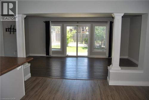 Unfurnished dining area featuring decorative columns and dark wood-style floors - 154 Harding Street, Kitchener, ON - Indoor