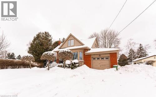 View of front of property featuring an attached garage, a chimney, and brick siding - 854 West 5Th Street, Hamilton, ON - Outdoor