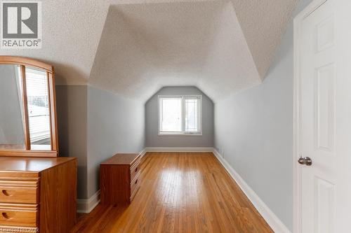 Bonus room with light wood finished floors, baseboards, vaulted ceiling, and a textured ceiling - 854 West 5Th Street, Hamilton, ON - Indoor Photo Showing Other Room