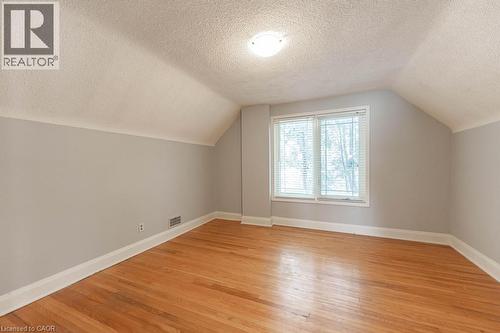 Additional living space with a textured ceiling, visible vents, baseboards, vaulted ceiling, and light wood-type flooring - 854 West 5Th Street, Hamilton, ON - Indoor Photo Showing Other Room