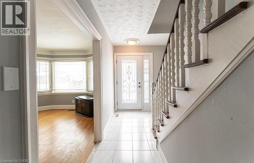 Foyer featuring baseboards, stairway, a textured ceiling, and light tile patterned flooring - 854 West 5Th Street, Hamilton, ON - Indoor Photo Showing Other Room