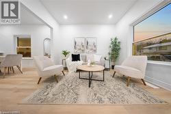 Living area featuring light wood-style floors, ornamental molding, and recessed lighting - 