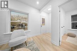 Living area with light wood-style flooring and arched walkways - 