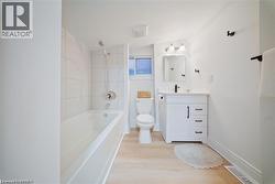 Bathroom featuring vanity, tub / shower combination, and light wood-style flooring - 