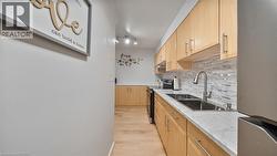 Kitchen featuring freestanding refrigerator, electric range, light brown cabinets, and backsplash - 