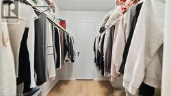 Walk in closet with light wood-type flooring - 