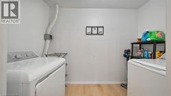 Washroom featuring light wood-style floors and washer and dryer - 