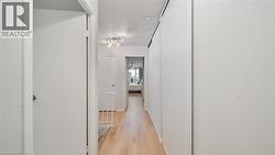 Hall featuring a textured ceiling and light wood-type flooring - 