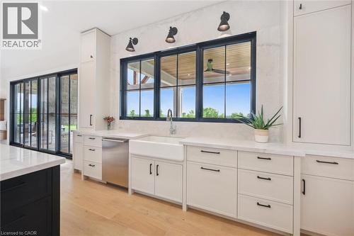 Kitchen featuring dishwasher, a sink, light stone countertops, and white cabinets - 5020 First Line, Erin, ON - Indoor