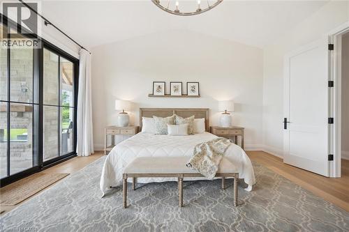 Bedroom with wood finished floors, lofted ceiling, access to exterior, baseboards, and a chandelier - 5020 First Line, Erin, ON - Indoor Photo Showing Bedroom