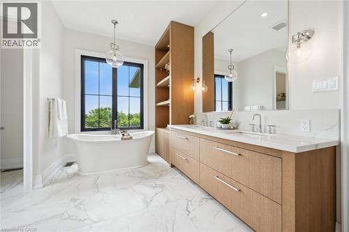Bathroom with double vanity, a soaking tub, baseboards, and marble finish flooring - 5020 First Line, Erin, ON - Indoor Photo Showing Bathroom