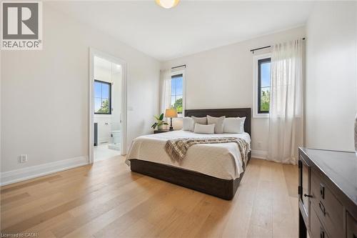 Bedroom featuring light wood-style flooring, baseboards, and ensuite bathroom - 5020 First Line, Erin, ON - Indoor Photo Showing Bedroom