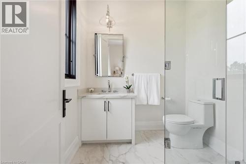 Bathroom featuring vanity, baseboards, marble look tiles, and toilet - 5020 First Line, Erin, ON - Indoor Photo Showing Bathroom