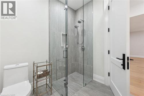 Bathroom with a tile shower, toilet, baseboards, and wood finished floors - 5020 First Line, Erin, ON - Indoor Photo Showing Bathroom