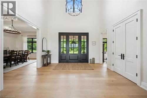 Foyer with a chandelier, light wood finished floors, a towering ceiling, and baseboards - 5020 First Line, Erin, ON - Indoor Photo Showing Other Room