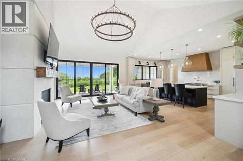 Living room featuring high vaulted ceiling, recessed lighting, a chandelier, a fireplace, and light wood-style flooring - 5020 First Line, Erin, ON - Indoor