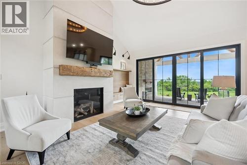 Living room featuring wood finished floors, a glass covered fireplace, and high vaulted ceiling - 5020 First Line, Erin, ON - Indoor Photo Showing Living Room With Fireplace