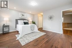 Bedroom with dark wood-style flooring and baseboards - 