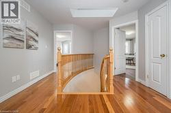 Hallway featuring an upstairs landing, hardwood / wood-style flooring, a skylight, and healthy amount of natural light - 