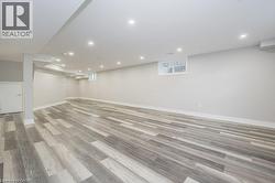 Below grade area with light wood-style floors and recessed lighting - 
