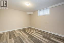 Below grade area featuring wood finished floors and a textured ceiling - 