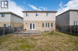 Back of house featuring a fenced backyard, a deck, french doors, and brick siding - 