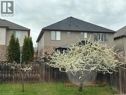 Back of property featuring brick siding and a shingled roof - 