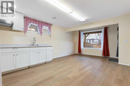 Lower-level living area, vinyl plank flooring - 129 Evansbrooke Way Nw, Calgary, AB - Indoor Photo Showing Other Room