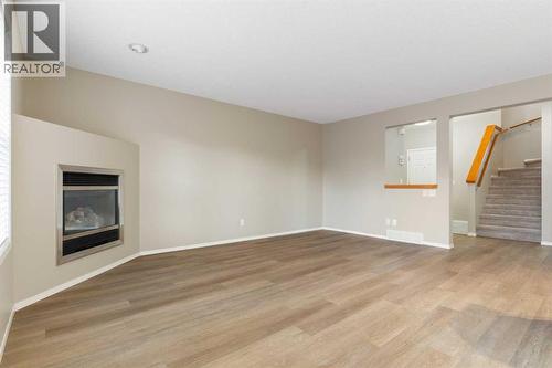 Living room and stairs to upper level - 129 Evansbrooke Way Nw, Calgary, AB - Indoor Photo Showing Other Room With Fireplace