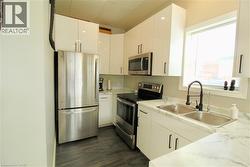 Kitchen with stainless steel appliances and white cabinetry - 