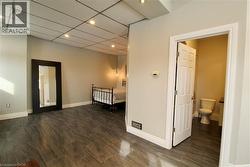Unfurnished bedroom with wood tiled floors, recessed lighting, and a paneled ceiling - 