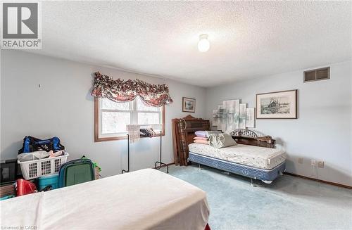 Carpeted bedroom featuring a textured ceiling and baseboards - 5 Charing Drive, Hamilton, ON - Indoor Photo Showing Bedroom