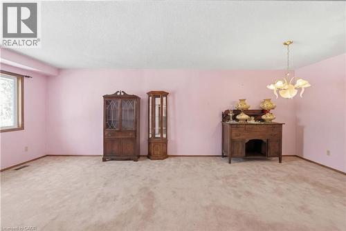 Unfurnished living room with suspended lighting, light carpet, and a textured ceiling - 5 Charing Drive, Hamilton, ON - Indoor Photo Showing Other Room